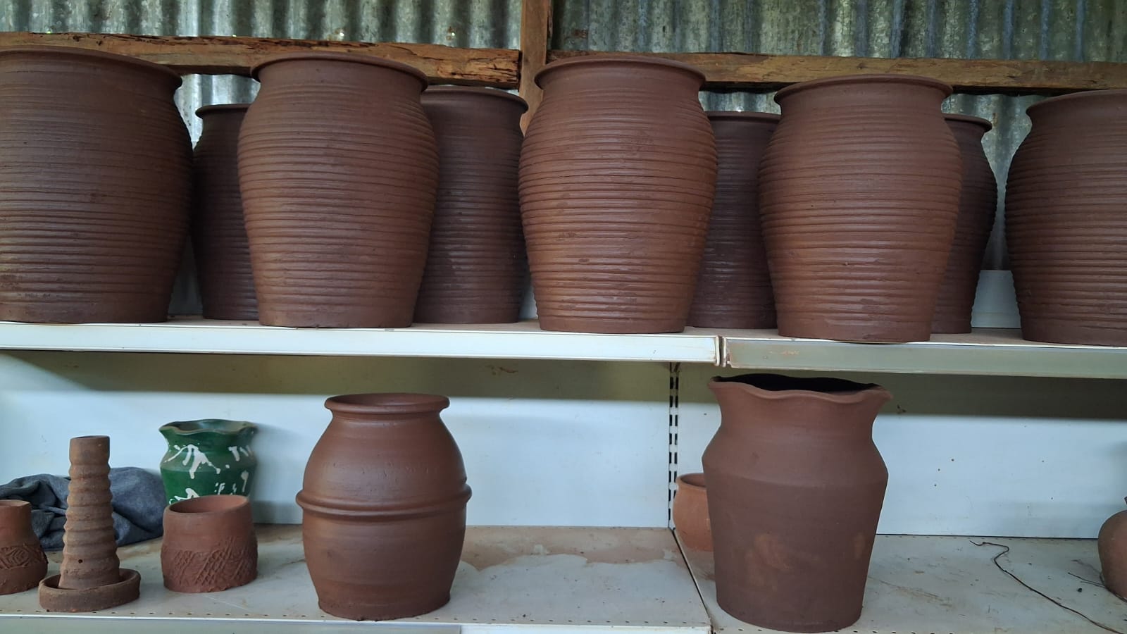 Large ribbed terracotta clay urns on shelves