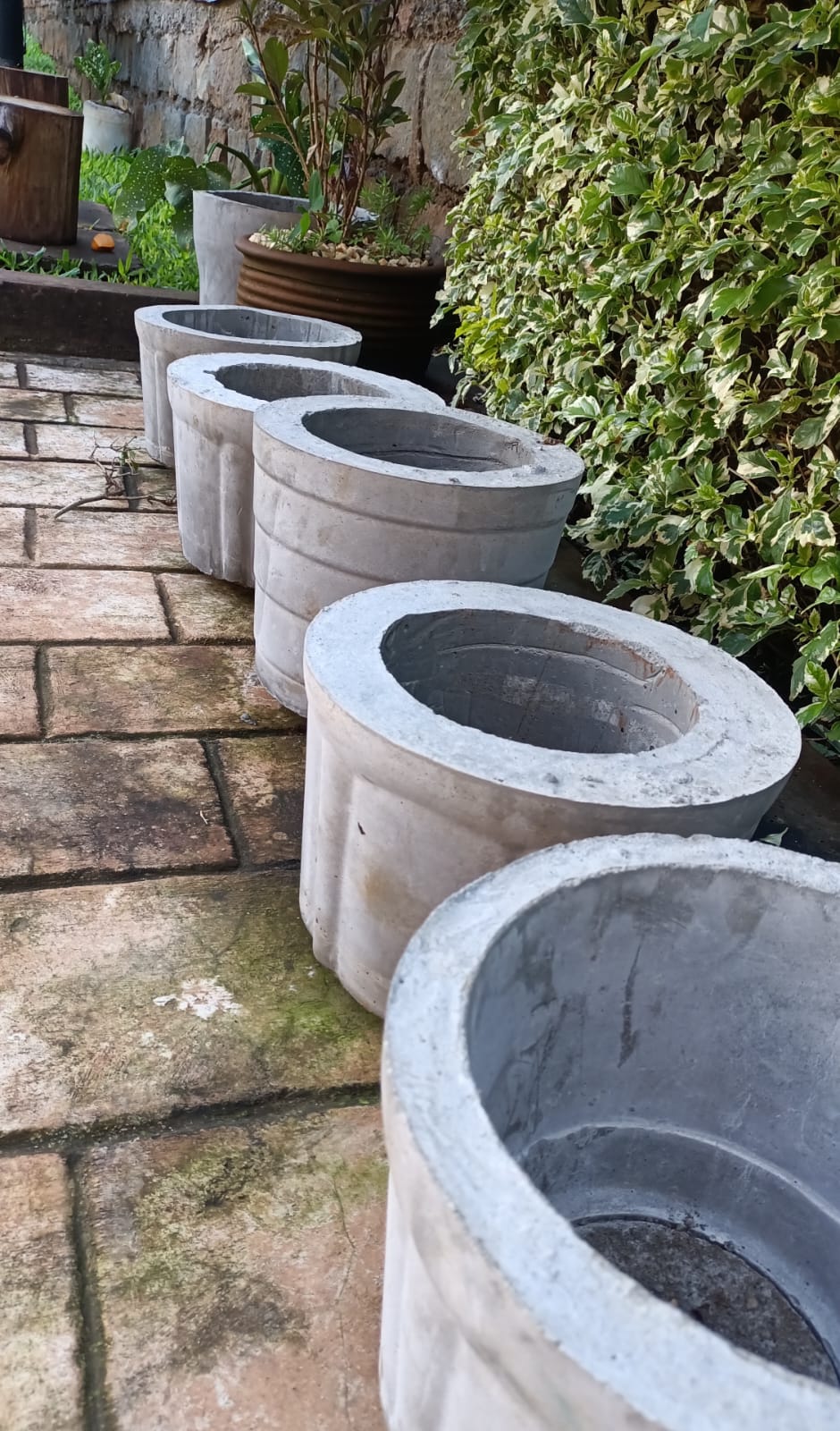 Large smooth concrete cylinder pots lined up outdoors – Jowaki Gardens