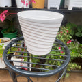 Side view of empty white ribbed plant pot