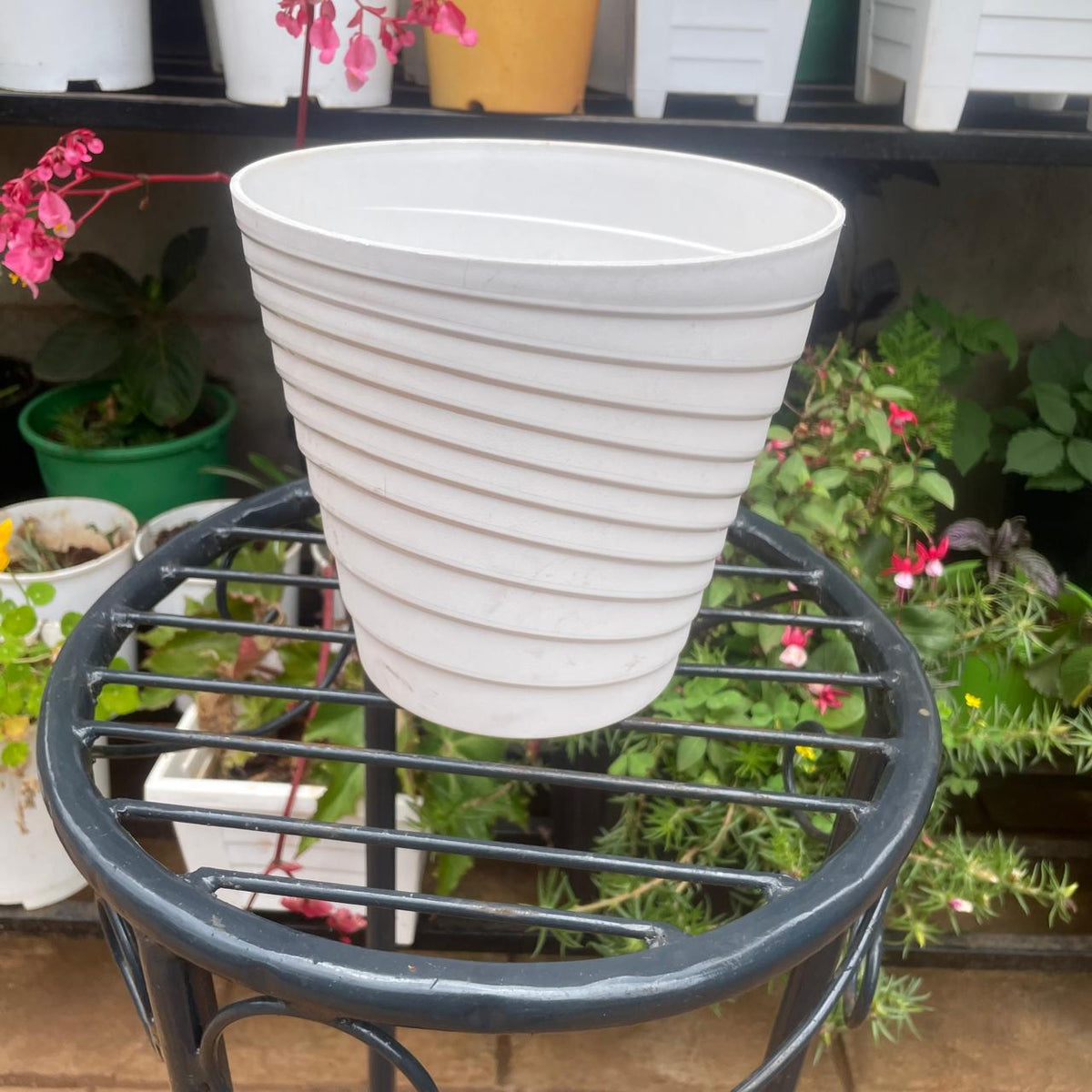 Side view of empty white ribbed plant pot